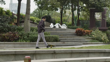 Un-Hombre-De-Negocios-Solitario-Y-Bien-Vestido,-Modelo-Masculino-Caucásico,-Caminando-En-El-Parque,-Pradera-Verde,-Zona-Residencial-Del-Distrito-De-La-Moderna-Ciudad-Inteligente.