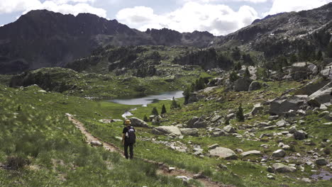 senderista solitario caminando solo en las montañas camino con vista panorámica sobre el parque nacional de aiguestortes ubicado en los pirineos catalanes españa durante un día soleado