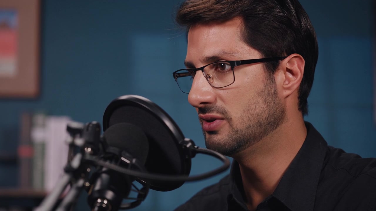 Giovane uomo che parla in un microfono in uno studio casalingo