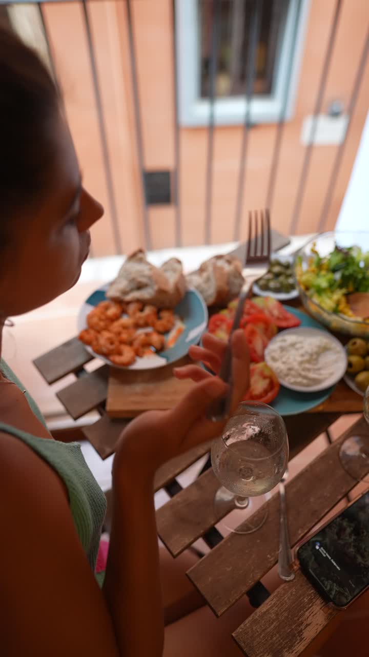 mujer disfrutando de una comida en un balcón