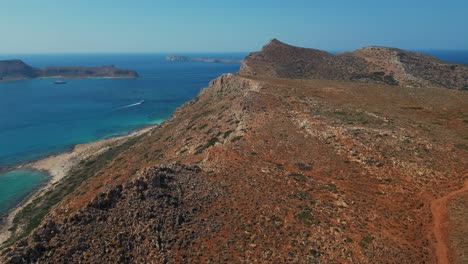 steep rock mountains towering over balos beach in chania, crete, greece. aerial drone shot