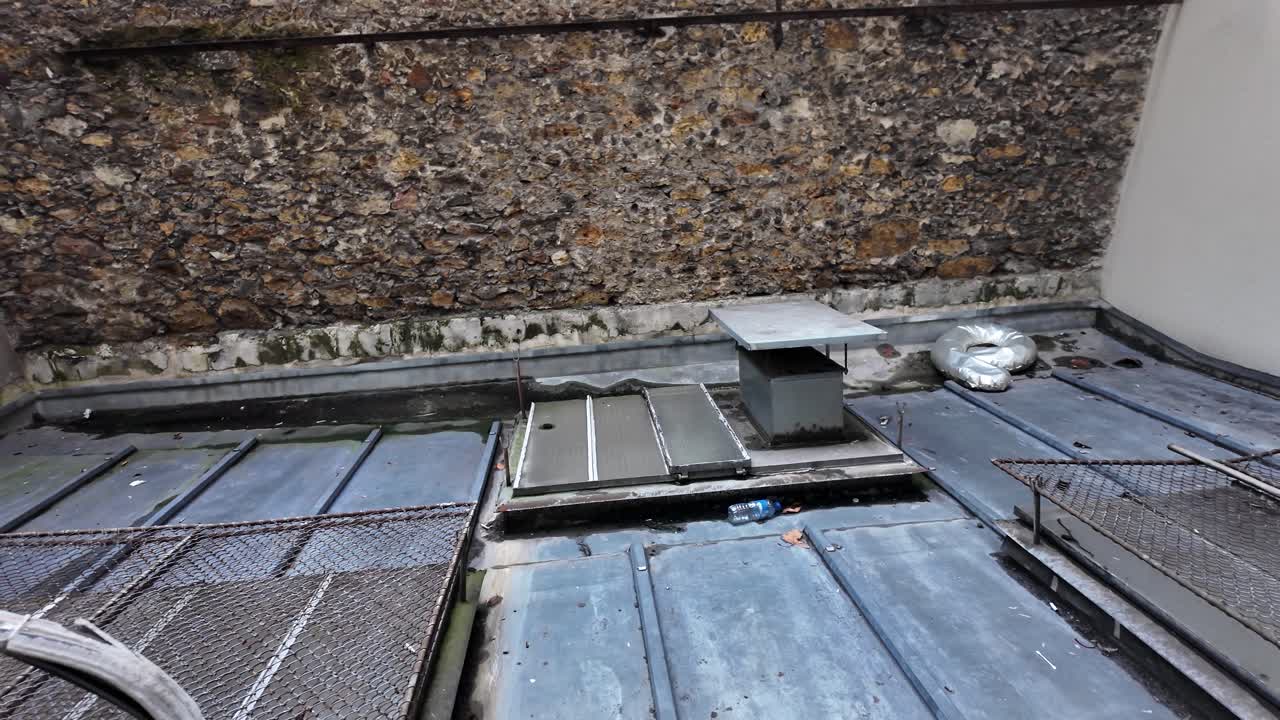 Paris Rooftop View With Stone Wall And Metal Structures Showing Urban Landscape And Architectural Details In A European Cityscape Setting Suitable For Travel Content