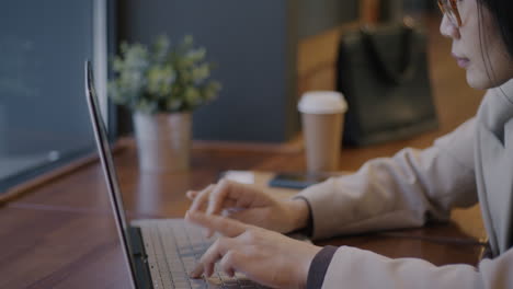 mujer trabajando en una computadora portátil en una cafetería