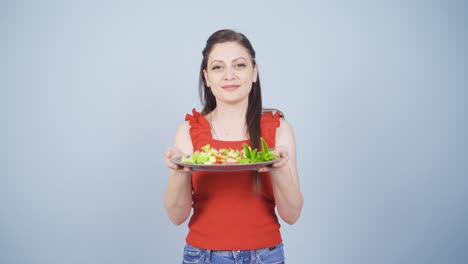 la persona que sostiene un plato de ensalada se está riendo.