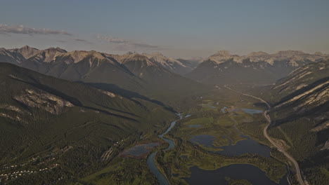 Banff,-AB,-Kanada,-Luftaufnahme-V30,-Hoher-Überflug-über-Bewaldete-Täler,-Der-Den-Gewundenen-Lauf-Des-Bow-River,-Die-Stadt-Am-Fuße-Der-Berge-Und-Die-Aussicht-Auf-Die-Sulphur-Mountain-Ranges-Einfängt-–-Aufgenommen-Mit-Mavic-3-Pro-Cine-–-Juli-2023