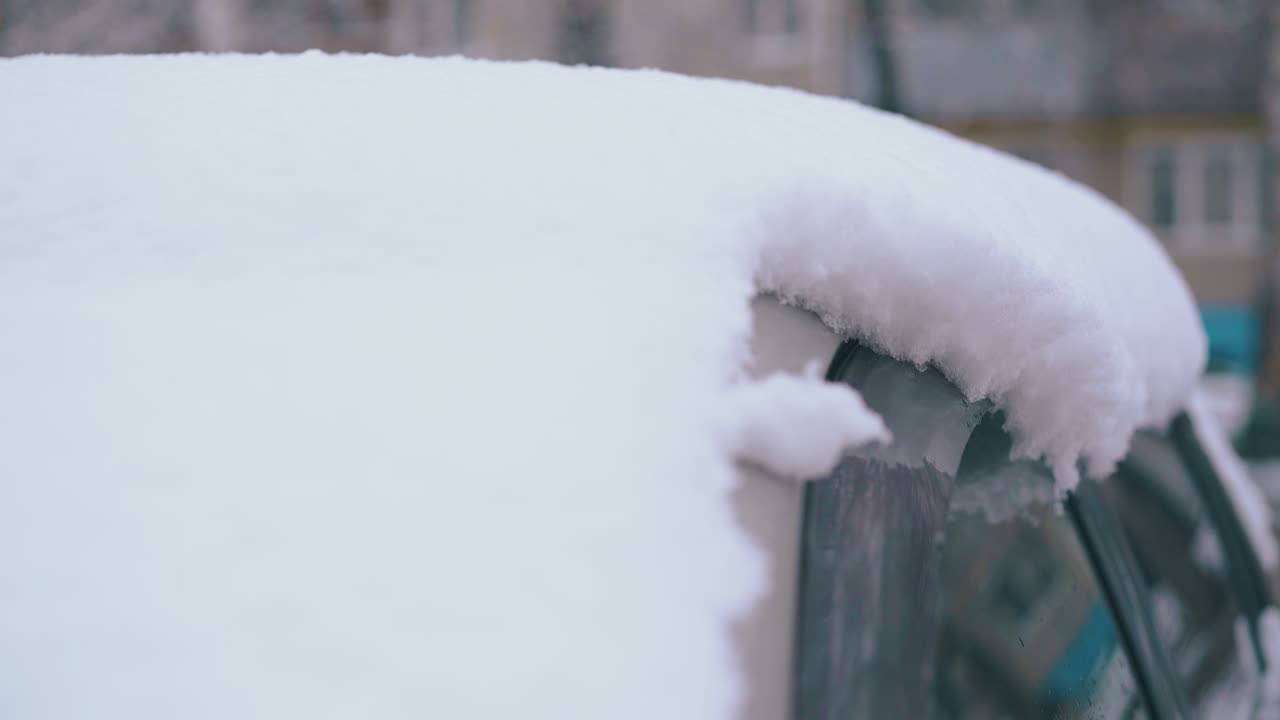 una gruesa capa de nieve en el techo del coche después de las nevadas en el día de invierno