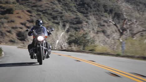 Ein-Mann-Fährt-Mit-Einem-Motorrad-Eine-Bergstraße-Hinunter