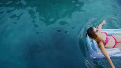 mujer caucásica disfrutando de la piscina durante un día soleado