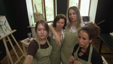 Portrait-of-lovely-women-at-workshop-looking-together-on-artwork