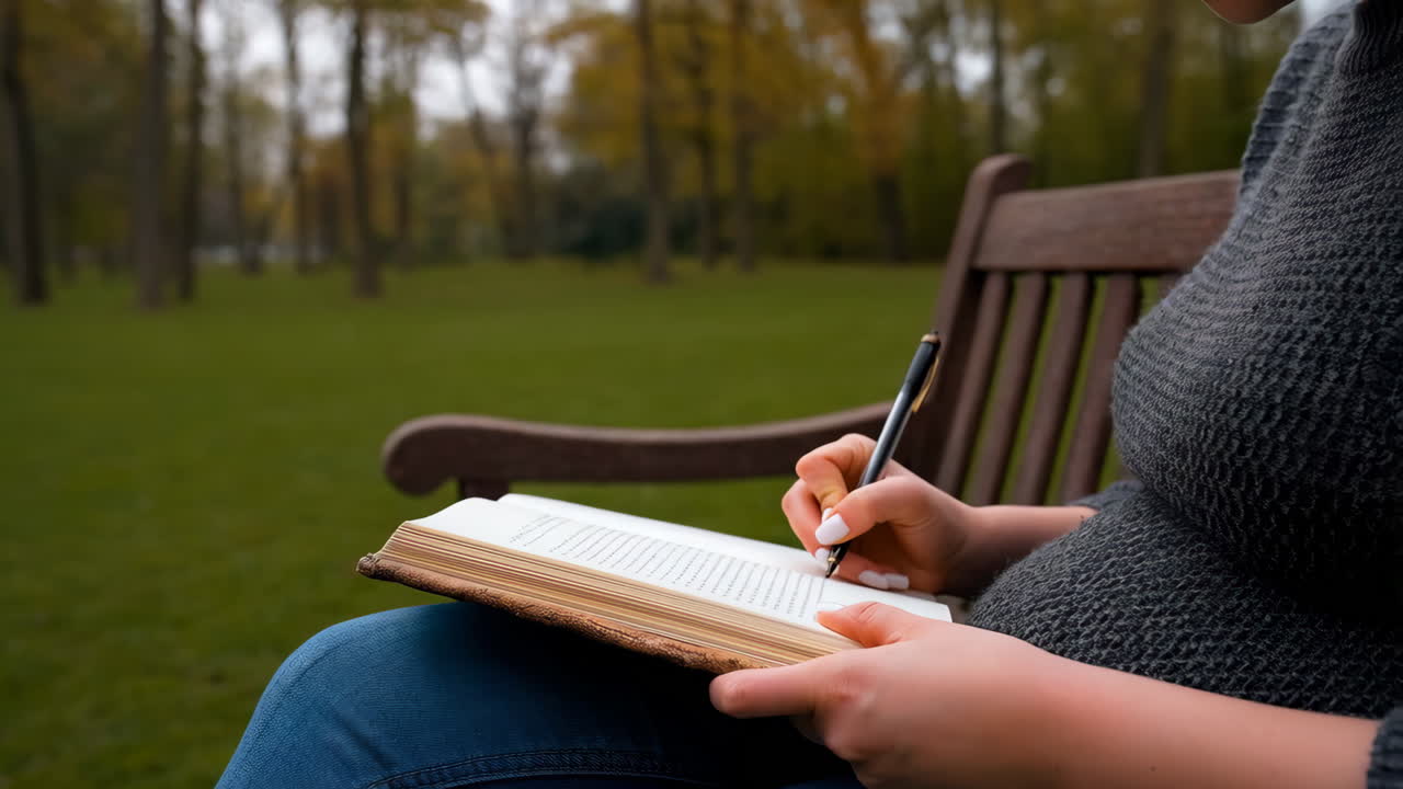 Person Writing in a Book on a Park Bench
