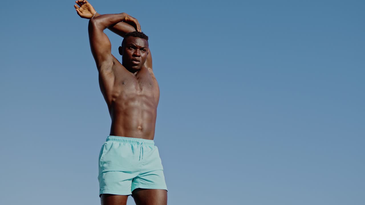 Athletic African man exercising outdoors in swim trunks
