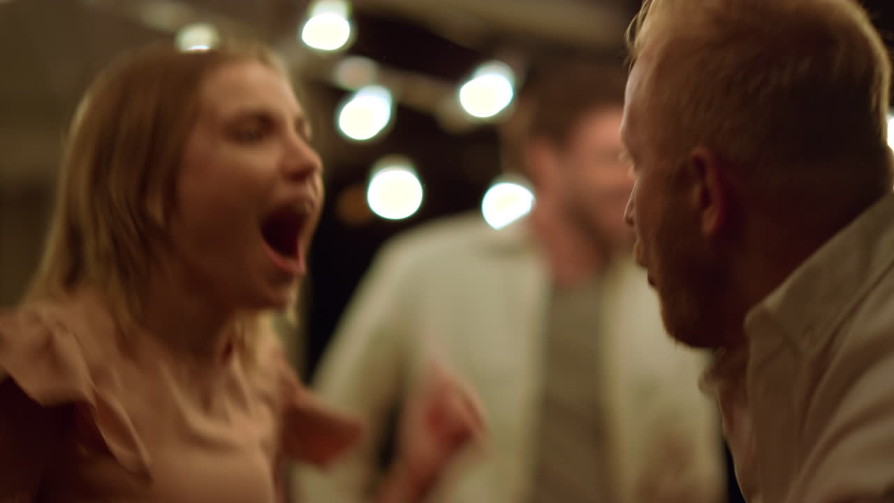 춤추는 동안 점프하는 친구들. 새해 파티에서 즐거운 시간을 보내는 긍정적인 커플