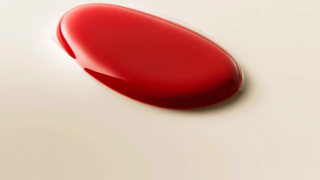 A red droplet dynamically transforms its shape and size on a clean white surface, captured from a top-down perspective. This neutral scene is commercial product displays and vivid.