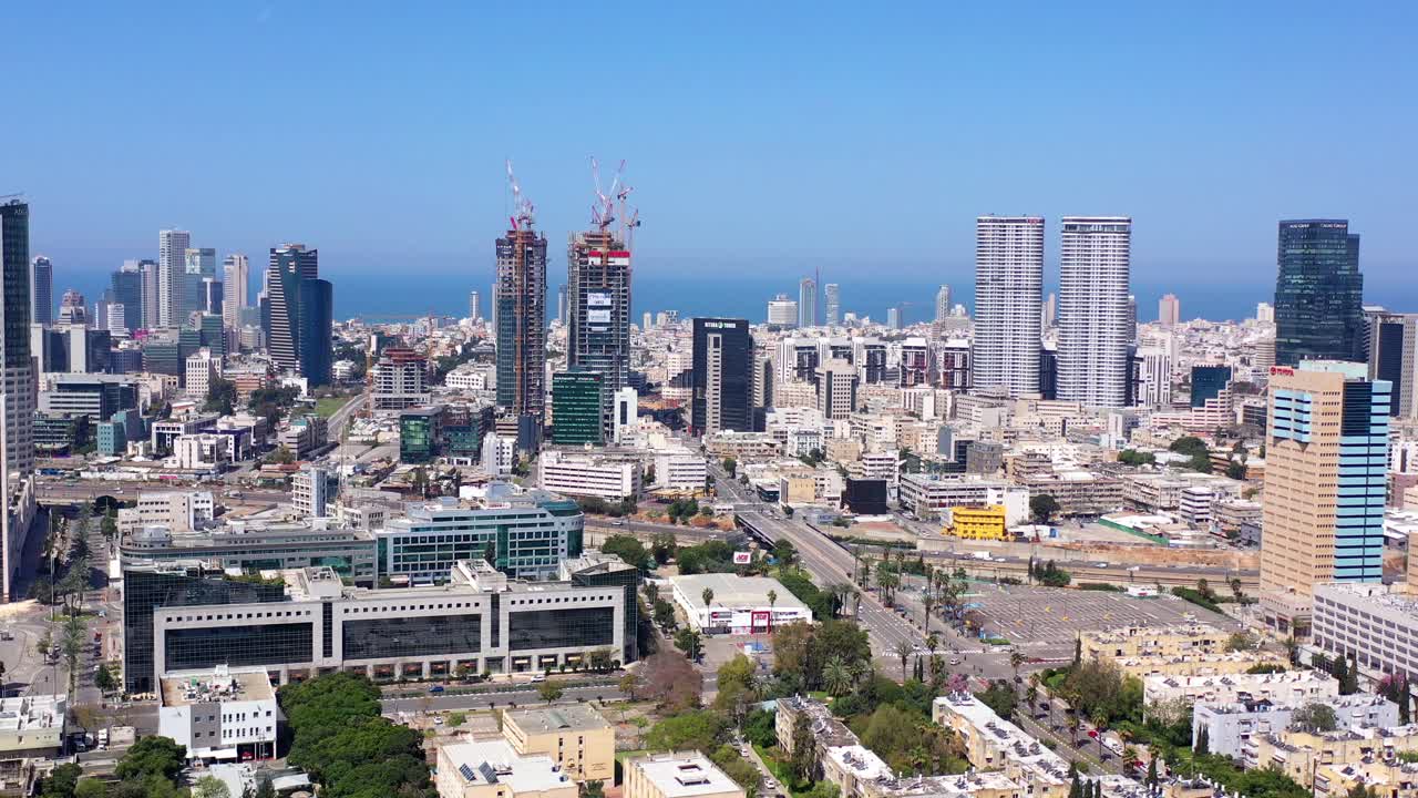 Aerial view of Tel Aviv skyline with modern buildings, construction cranes, and coastal view