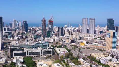 aerial view of tel aviv skyline with modern buildings, construction cranes, and coastal view