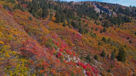 Drone-flying-closely-to-colorful-mountain-side