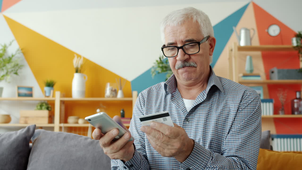 Senior Man Using Smartphone and Credit Card for Online Payment