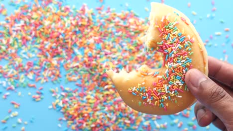 a bite of colorful sprinkled donut