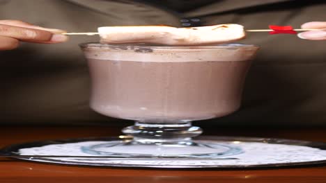 persoon die warme chocolade met marshmallow eet