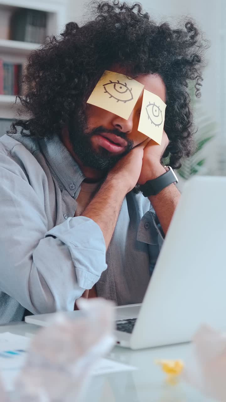 Young lazy funny arabian man office worker with paper stickers on eyes sleeps