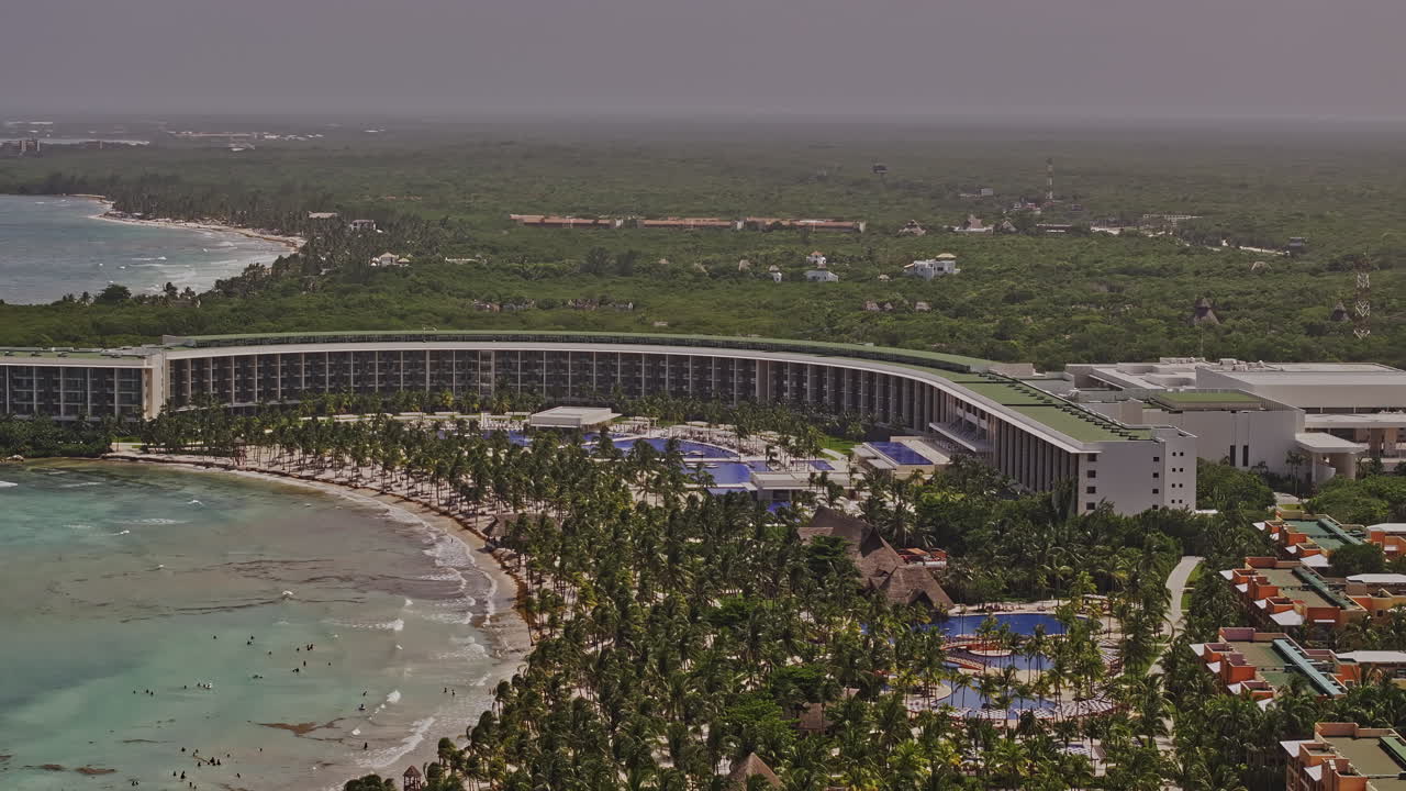 puerto aventuras méxico aerial v6 zoom shot, drone flyover resort hotel frente al mar con hermosa playa de arena y amplias vistas al océano - filmado con mavic 3 pro cine - julio 2023