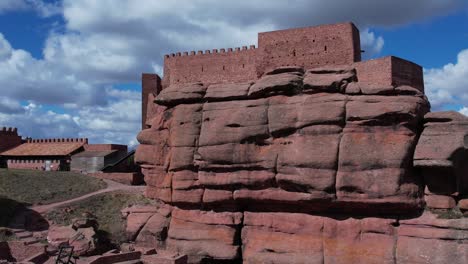 Aerial-drone-view-of-the-Peracense-castle,-in-Teruel-,-bulit-in-the-X-century-with-red-sandstone-in-the-top-of-a-hill,-with-a-nice-changing-sky