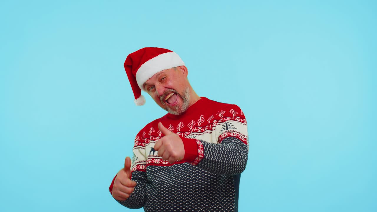 웃긴 남자는 사과 함께 빨간 새해 스웨터를 입고 엄지손가락을 올리며 좋은 것에 동의합니다.