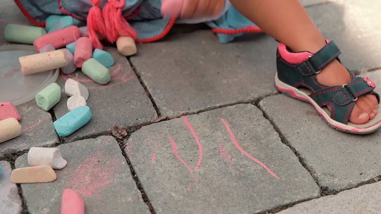 un niño con muchas pinturas de tizas de colores en los azulejos