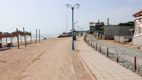 paseo panorámico en la playa de vama veche con sombrillas de paja en un día soleado de verano en constanta, rumania