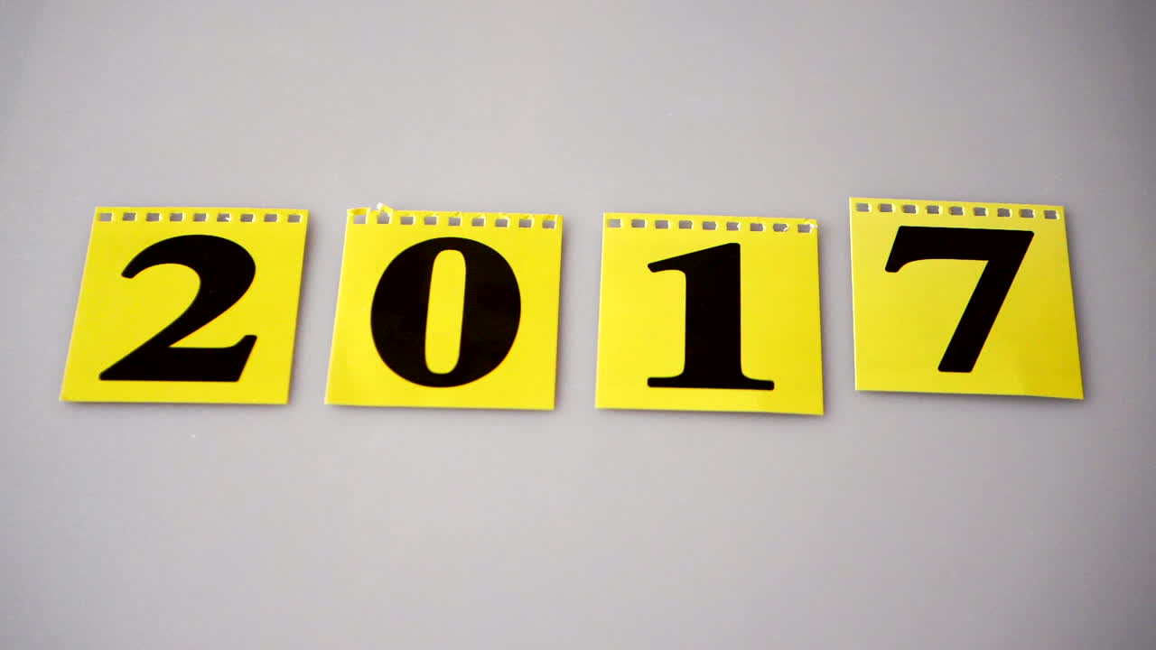 Yellow flip calendar changes to a new year hand