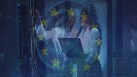 animation of eu flag over african american couple using laptop in server room