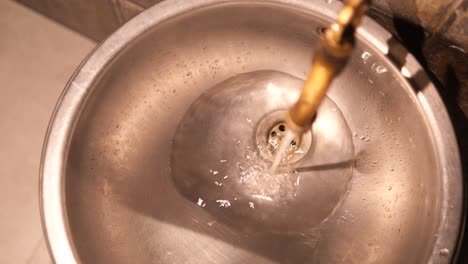 water running into a stainless steel sink