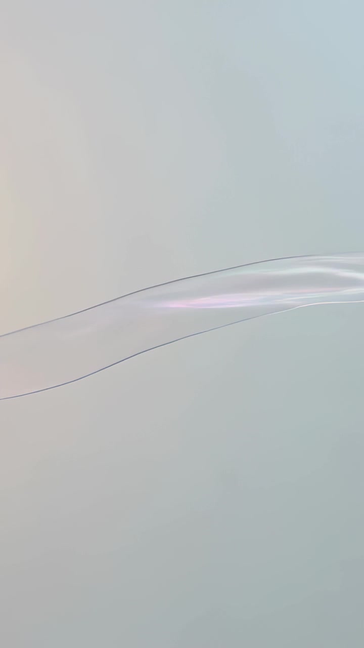 Vertical video: Gliding translucent ribbon starting near warm glow, crossing pale blue gradient