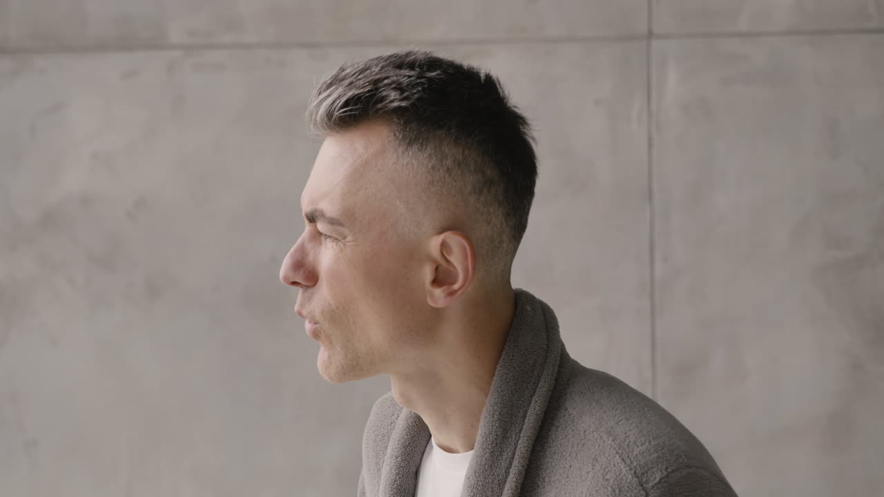 집에서 복통을 앓고 있는 잠옷과 가운을 입은 중년 남성