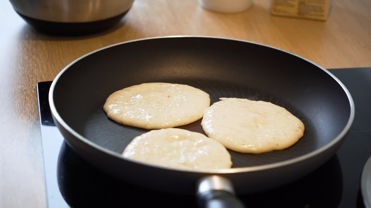 el primer plano de freír panqueques en la sartén en la cocina de casa, proceso de preparación del desayuno