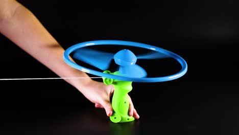 hands operate a pull string flying toy