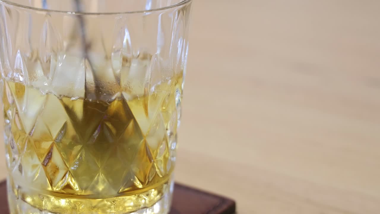 un vaso de whisky con hielo, escena estática