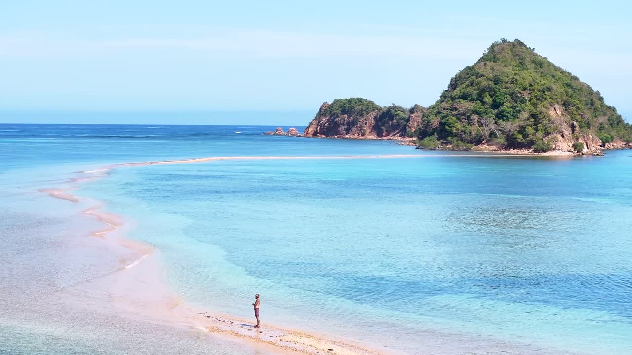Man standing on sand bar a watching amazing tropical coastal of Coron, Philippines. Drone