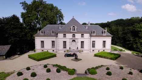 a drone advance towards the château de limatge, passing above the french garden and the slate roof