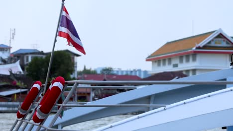 a boat with a waving thai flag