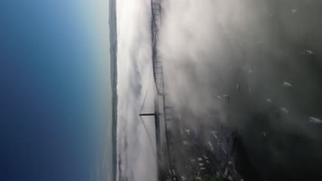 vertical morning fog over the river tamar between saltash and plymouth, aerial drone shot
