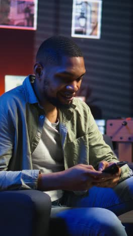 vertical video smiling young adult chatting with friends over texts on mobile phone
