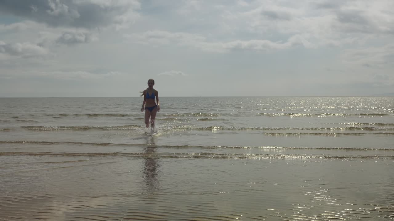 젊은 소녀 달리기, 바다 물, 해변 위치, 황금 태양, 느린 동작