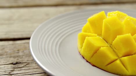 Chopped-mangoes-in-plate-on-wooden-table