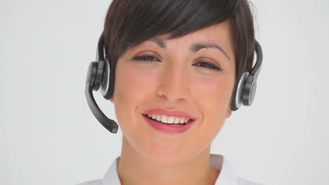 mujer de negocios sonriendo mientras habla a través de un auricular