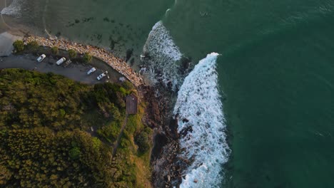 Blick-Hinunter-Auf-Einen-Beliebten-Surfspot-Mit-Wellen,-Die-Um-Eine-Manipulierte-Landzunge-An-Einem-Beliebten-Urlaubsort-Schlagen