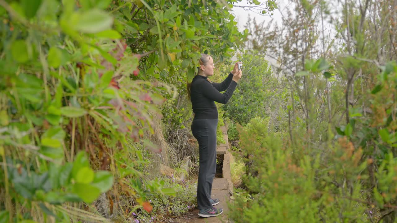 mujer joven tomando fotos de la naturaleza de la isla de tenerife, vista de mano