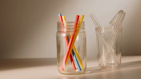 colorful and clear reusable drinking straws in glass jars