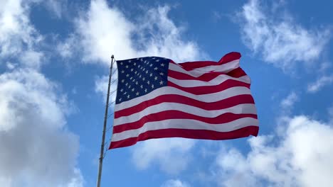 American-Flag-Proudly-Waving-In-The-Clear-Blue-Sky---Tilt-Up-Shot