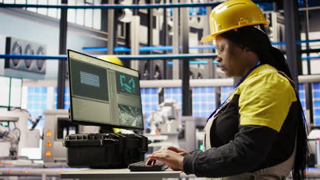 Vertical video Technician in industrial plant monitors production equipment using PC software